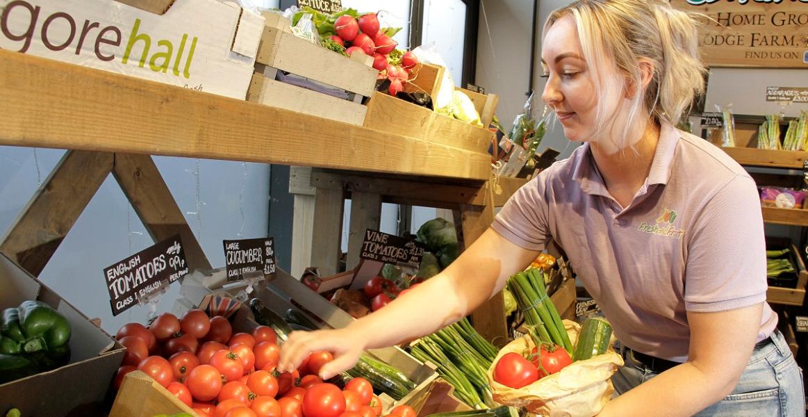 Fresh and Fruity trader putting vegetables into a bag