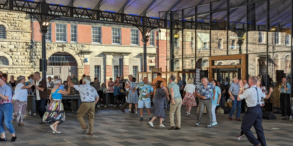 People dancing outside Preston Market Hall to The Jive Aces