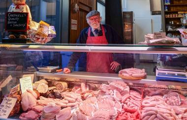 Trader behind stall with assortment of meats