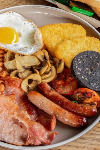 Full English breakfast with sausages, bacon, hash browns, black pudding, mushrooms, tomatoes and beans