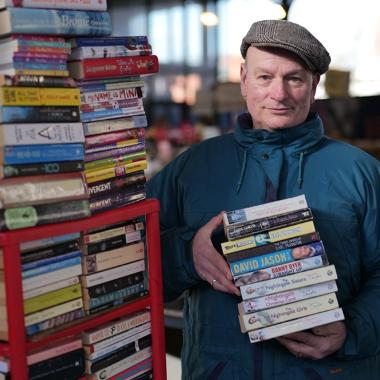 Trader holding books at The Book Stops Here