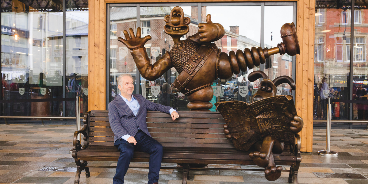 Nick Park sitting on the Wallace and Gromit bench